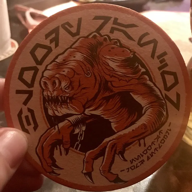 a Rancor themed beer mat/coaster - Oga's Cantina Menu with Pictures