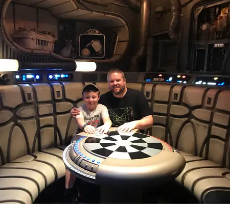 Me and my son sat at the Chess Board inside the Millennium Falcon
